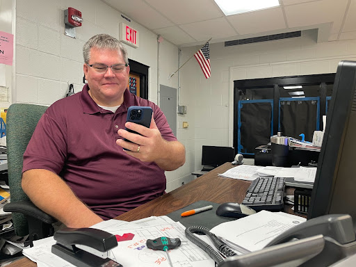 FHN Engineering teacher Mike Green uses his new iPhone 15 at his desk in his classroom.
