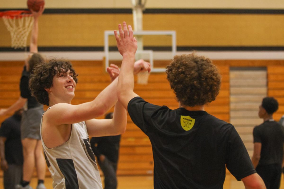 Brothers Elijah and Isaac Bollinger high-five during a basketball practice on Nov. 13. 