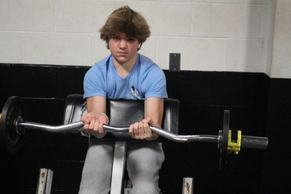 An FHN student does bicep curls in
the weight room.