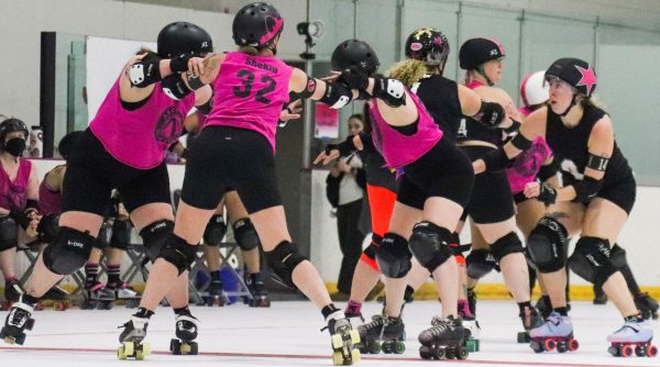 Girls in the Roller Derby team skate during a match.