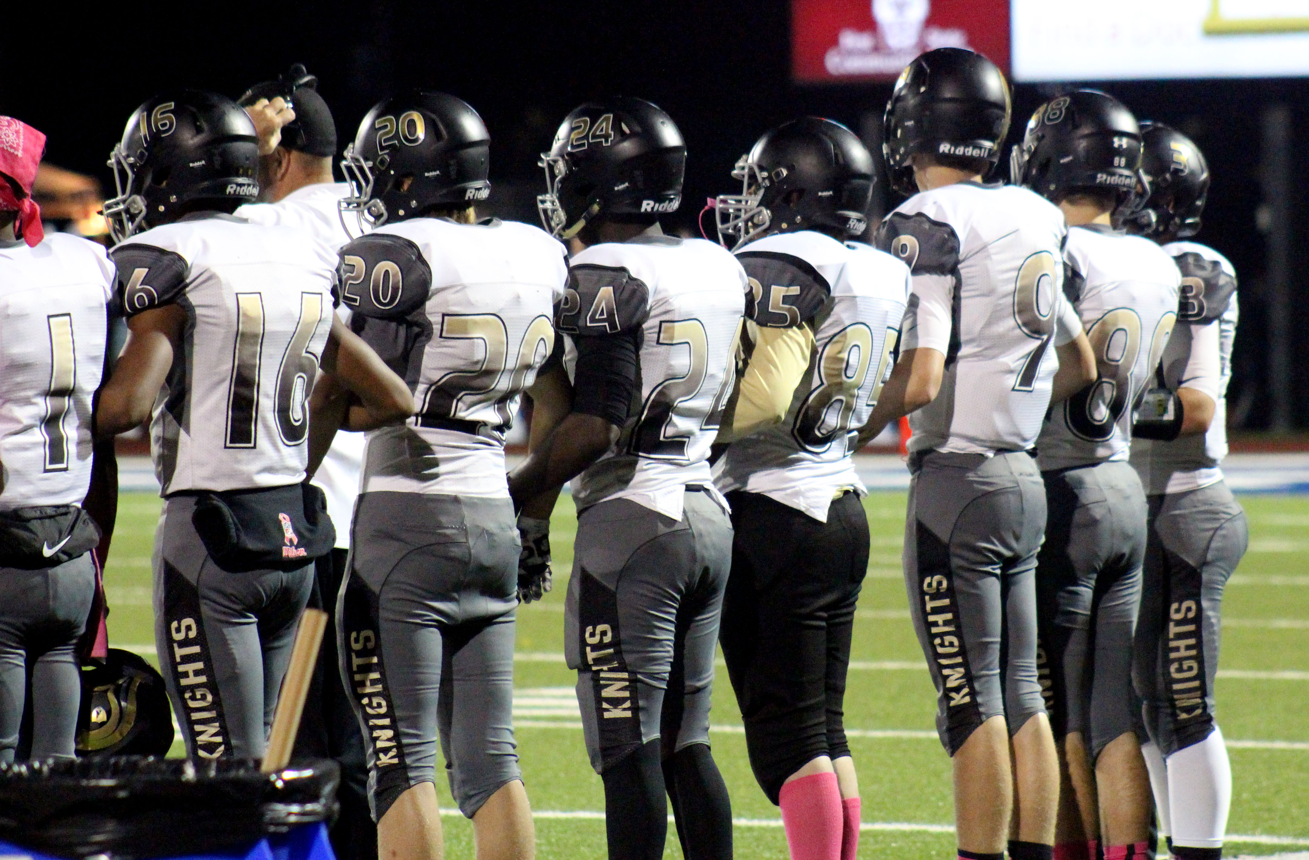 Players link arms before the game against WHS as the coin is tossed (Michal Basford)