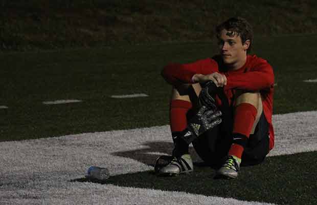 Senior goalkeeper Fletcher Dietrich sits near the goal during a stoppage in play in the second half (Adam Quigley)