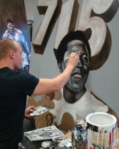 Zack Smithey paints Hank Aaron for Ozzie Smith's charity.