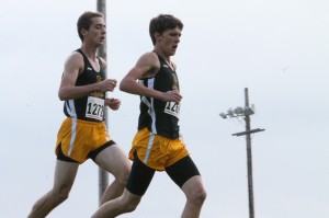 Clayton (left) runs alongside teammate Brenton Griffith during a race.