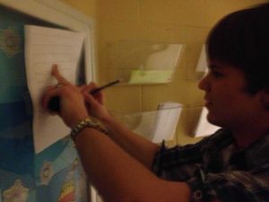 Junior Michael Beaver writes the answer to one of the trivia questions. 100 total were scattered around the school.