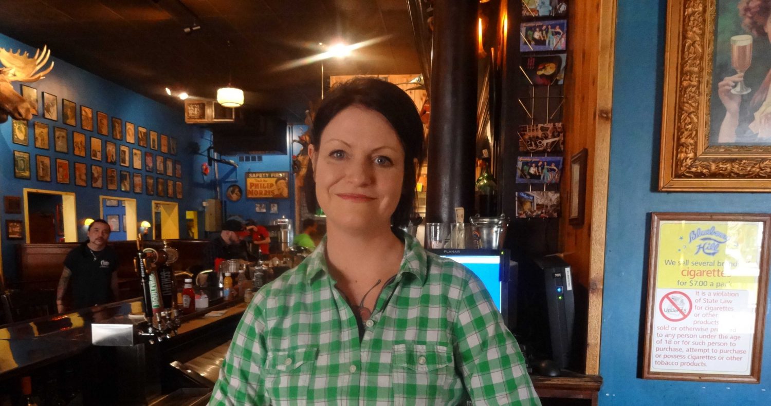 Bar Manager Becca Schock stands behind the bar waiting to serve customers.