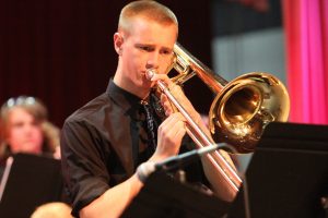 Band student Simon Hart plays his trombone on stage during the winter concert. 