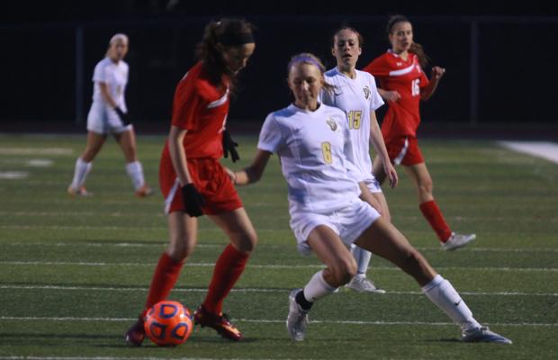 Sophomore Betty Joe attempts to steal the ball from her opponent .  