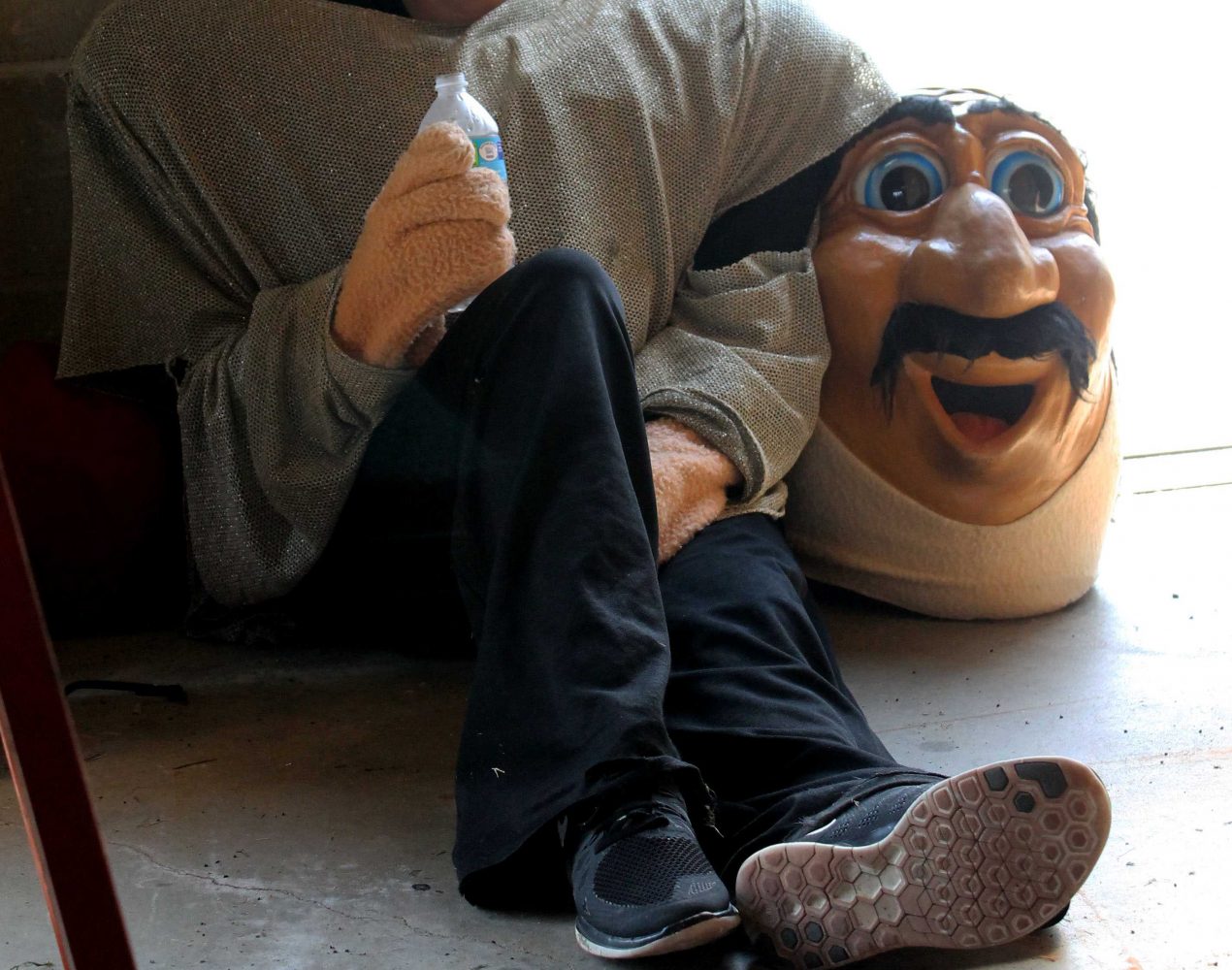 Norm takes a break in the storage garage by the track. Norm had to take several breaks throughout the day because of the heat. The mascot worked hard visiting all of the booths, dancing with the cheerleaders, playing with the football players, and leading the parade of athletes.