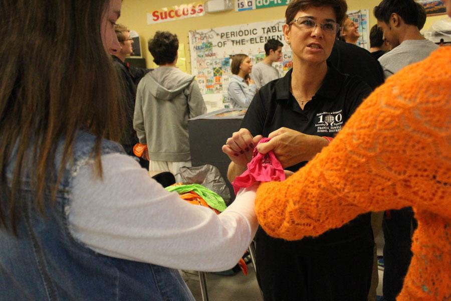 Chemistry teacher Donna Malkmus ties together junior Olivia Sontheimer and freshman Stephanie Monson for the Mole Day scavenger hunt on October 23. Partners for the scavenger hunt are tied together to make it more challenging and fun. The teachers used to tie ankles instead of wrists until someone fell down the stairs.