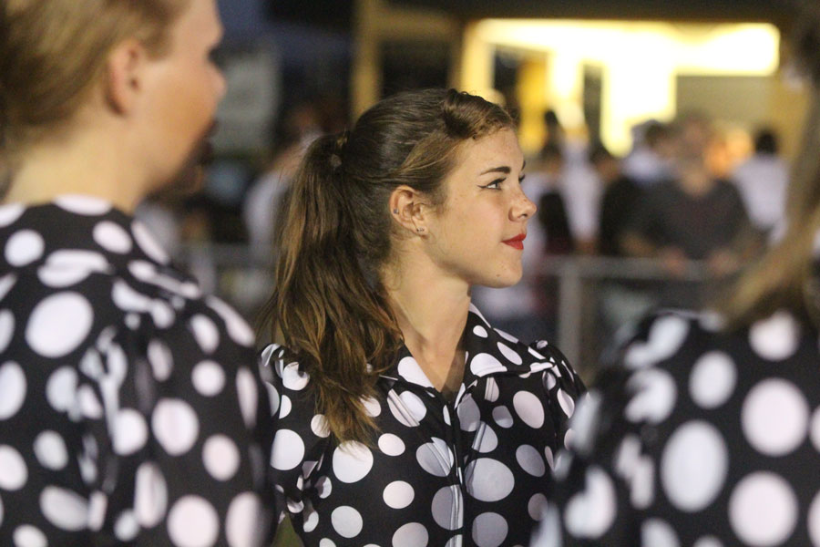 Arata stands in a huddle with the rest of the guard as they prepare themselves for their performance. The team always huddles before each performance to take a deep breath. The girls practice by the entrance to the field before half time to squeeze in a little more practice time. 