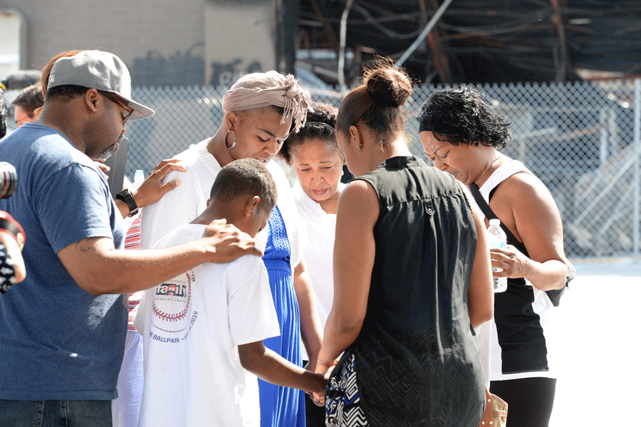 Group prays at the site of destroyed Quick Trip after Police Chief Thomas Jackson release of the name of the officer that shot Michael Brown.