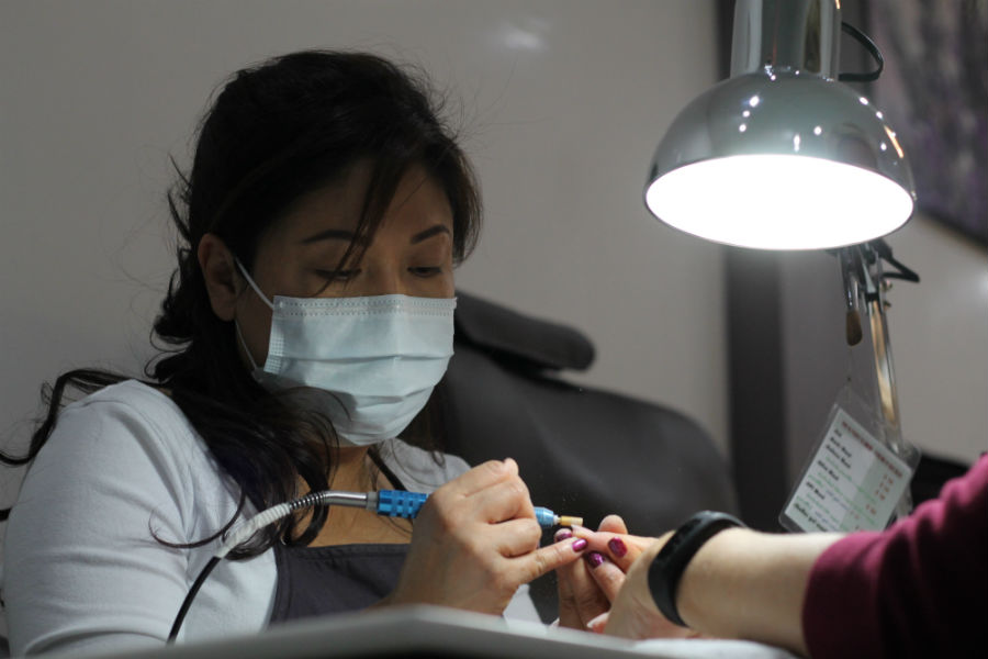 Nguyen removes a cuticle from a customer's nail during a manicure. The basic manicure is $13, however, Diva Nails also offers manicures to children under 10 years old for $10. Diva Nails offers other types of manicures including acrylic nails, solar nails, sculptured nails, deluxe manicure, qtica manicure, and OPI manicure. 