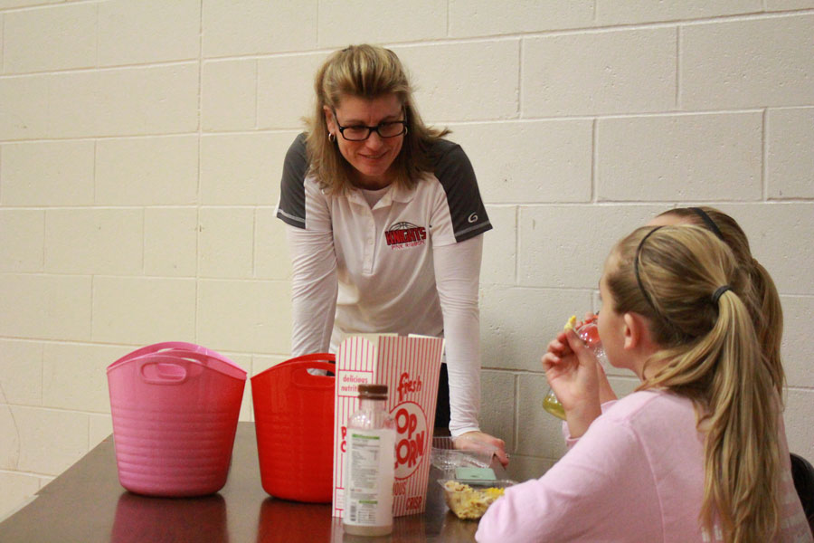 Mrs. Hahn goes to check on the donations table to see what funds they have raised from the Pink Ribbon Week games. Mrs. Hahn, trying to help people with cancer, held a fundraiser on Feb. 5 to receive donations to help aid people and hospitals with cancer. People put dollar bills and spare change into the pink and red buckets to support this good cause.