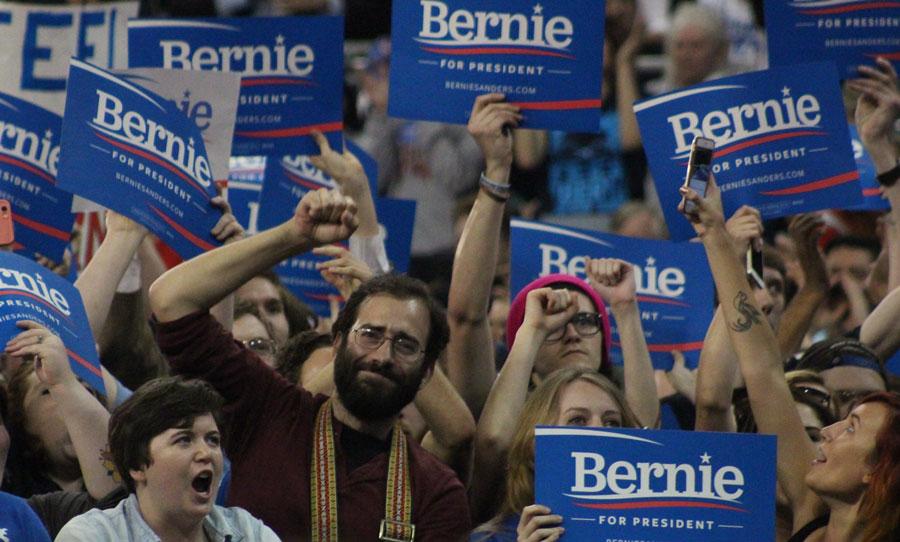 A man puts his fist in the air during Sanders’ speech. Sanders has spoken about free college, paid maternity leave, and the expansion of social security. Many young adults have been found to support Sanders. 
