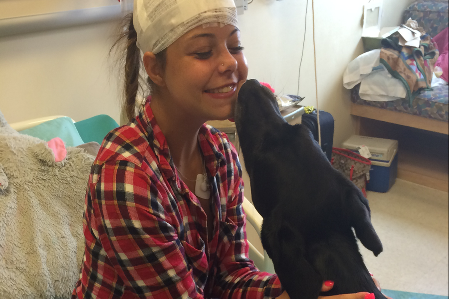 Paiton Savage is visited by one of the comfort dogs while she was in the hospital in July 2016  for her electroencephalogram (EEG). An EEG figures out what parts of the brain aren't acting normally through electrical activity.