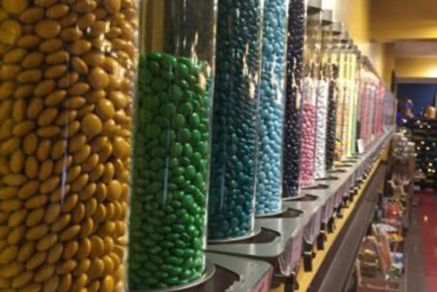 Machines of different colored M&M's and different flavored Jelly Beans line the wall of Sugar Cubed