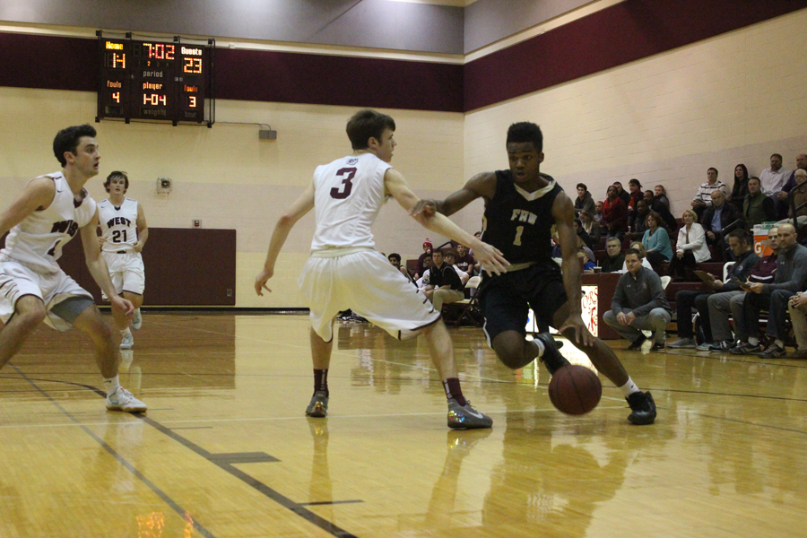 Junior Justin Matthews drives in for a lay up at the seventh place game in the St. Charles West Warrior Classic tournament on Dec. 9. The final score was 68-54, SCW.