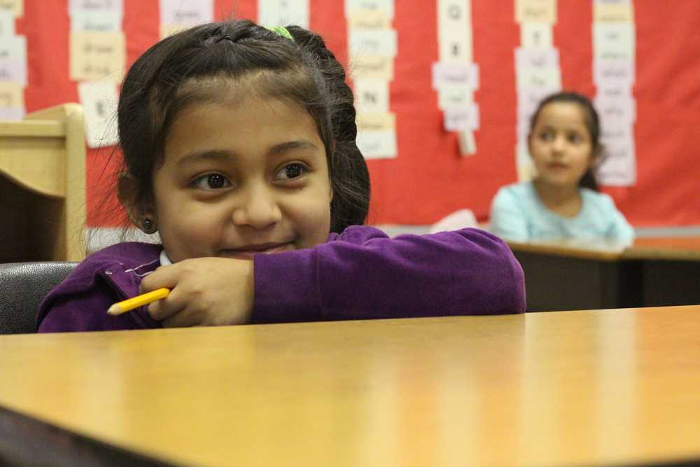 A student smiles as she looks on at the rest of her classmates. Nahed Chapman's enrollment has doubled since the beginning of the school year, leading to a rise in the student to teacher ratio.