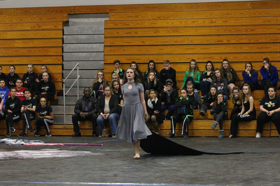 Sophomore Jacqueline Jansen pulls a tarp during the winter guard performance titled "Remembering You." (photo by Michaela Erfling)