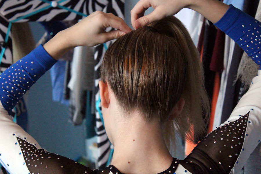 Jensen puts her hair up into a ponytail in preparation for her competition. Ponytail's must be only a palm's length away from the forehead or closer, accoridng to cheer regulation. This is so the bow rests a little over the forehead. 