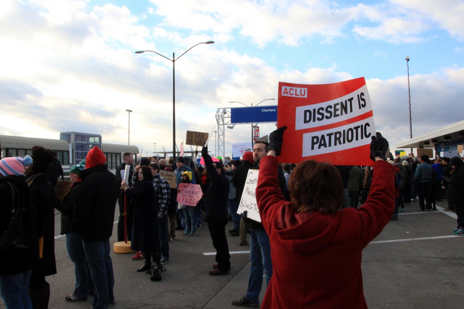 A representative of the ACLU holds a sign at a protest against President Donald J Trump's executive order, barring travelers from many predominantly-Muslim countries. The photo was part of a photo gallery in a nationally-recognized multimedia piece covered by Chase Meyer. 