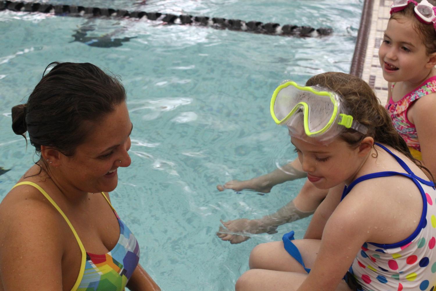 Swim instructor Emily Kolb talks to her students about the new skills they are going to be taught during that night's class. Kolb’s students learn how to float on their back and other basic swim strokes. 