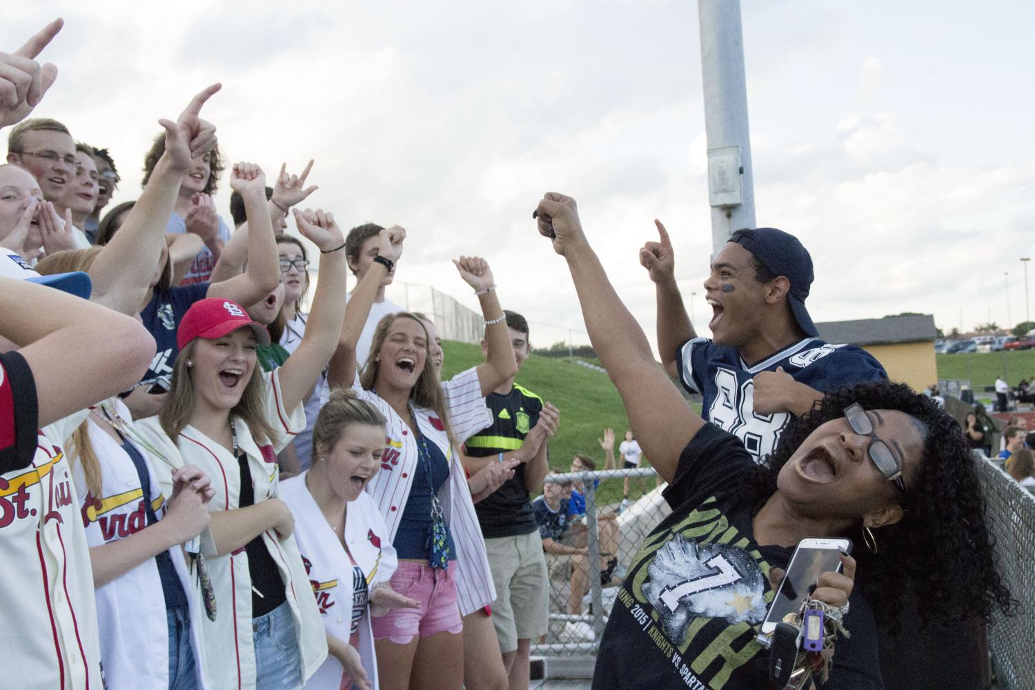 Laura Hawkins cheers in front of the student section as the Knights play on an August evening. 