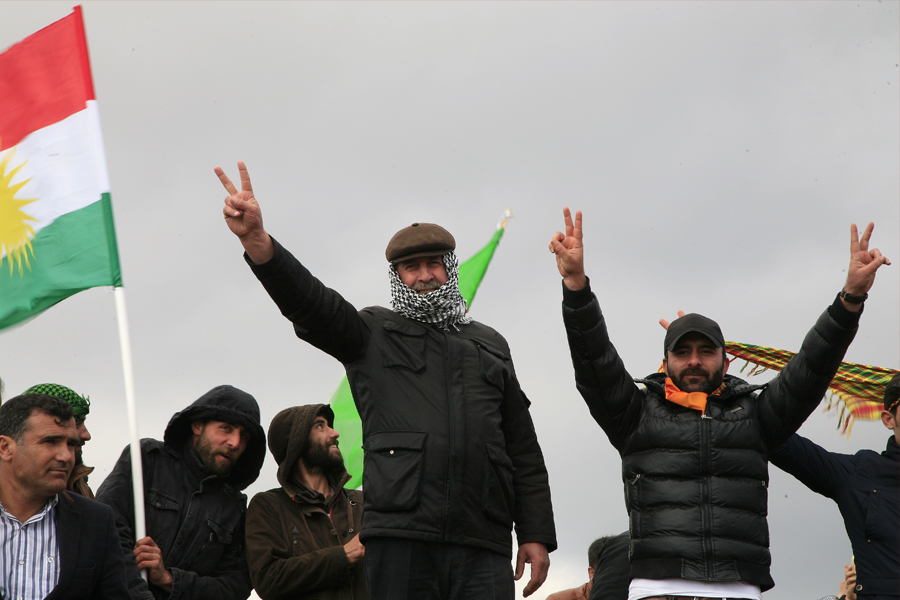 21 March 2015 - TURKEY. Kurds of iraq, with Hand Palm Showing Victory Sign, during Newroz festival in Diyarbakir. In background a flag of Kurdistan Region by the Iraqi constitution. Editorial credit: cristiano lissoni / Shutterstock.com