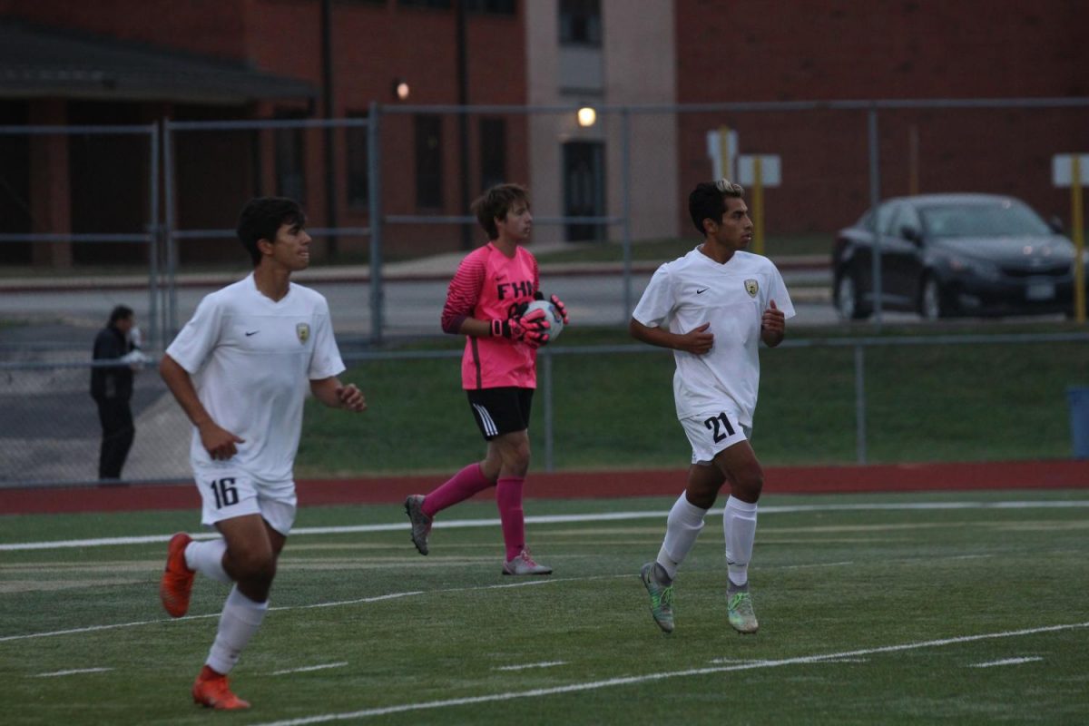 Goalkeeper Corey Valleroy collects the ball behind seniors Taylor Elzein