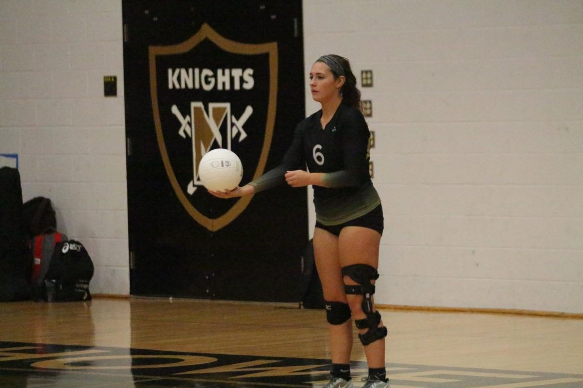 Senior Caty Arnold prepares to serve the ball.