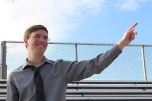 Dominic Hoscher, FHNGameday.com editor, points to the field on the bleachers of FHN. 