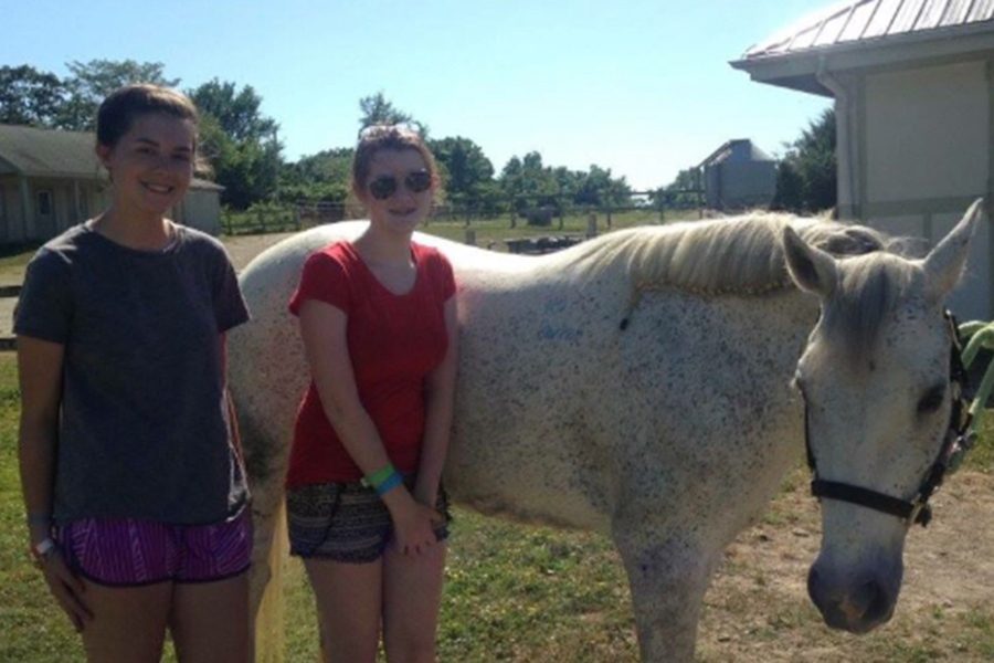 Sophomore Addy Bradbury poses with her horse in the stables. She started riding horses when she was in first grade.  (photo submitted)