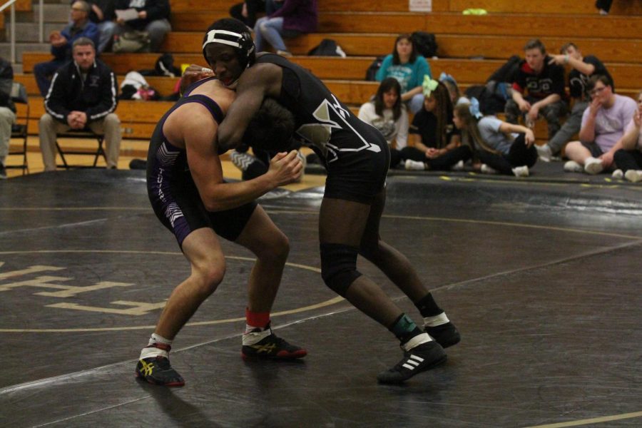 Varsity wrestler Josh Simmons grapples opponent from Troy Buchanan High School in FHN large gym.