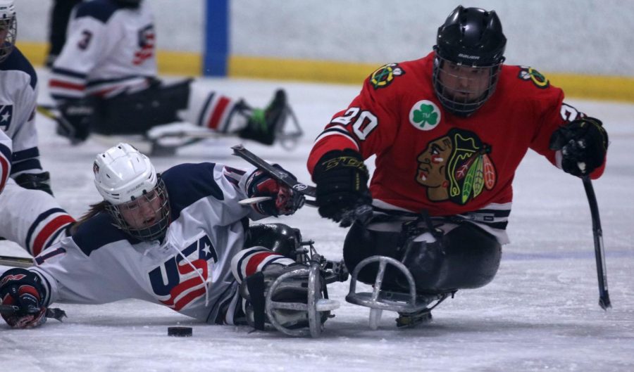 Kelsey DiClaudio goes for a tackle against a Chicago Blackhawk player.  DiClaudio is one of three players from Missouri on the team. She was born with a spinal cord injury which caused her to eventually be in a wheel chair. 