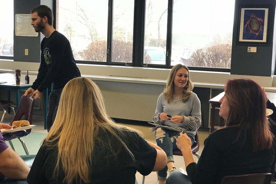 Falculty members Ryan Johnson, Tara Willen and Angie Davis sit in a circle with junior Erika Rogers as they share out ideas about team building.