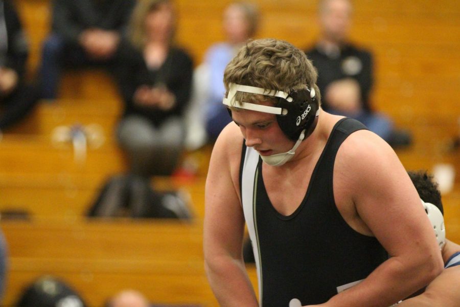 Senior Hunter Collins tries to escape grapple against opponent from Holt on FHN senior night  in the large gym.