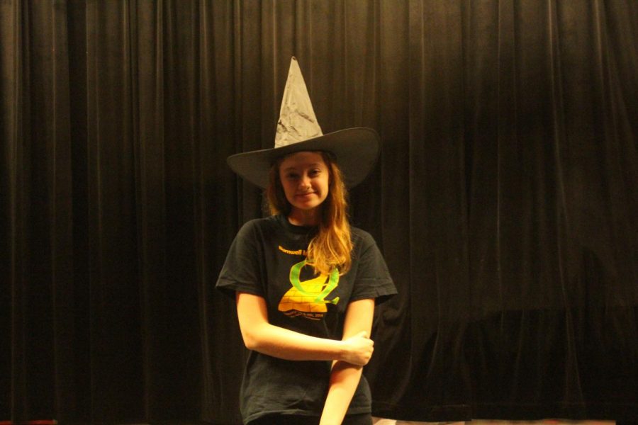 Senior Delaney Echelmeyer poses on the FHN stage in her witch hat. She has been involved in theatre for seven years. “My favorite part about performing is how a whole ensemble of people from such different lives can come together and create something incredible,” Echelmeyer said. 