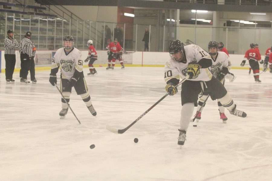 Senior Kurt Springli (#10) takes a shot on goal with fellow senior Jacob Casey watching in the background in warmups ahead of FHN's varsity hockey game vs. FZS on 11/10. 