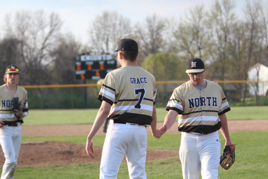 Seniors Sam Grace and Noah Pingel give each other a high-five as they head back to the dugout after the top of the fifth inning on 4/24 vs. Holt.