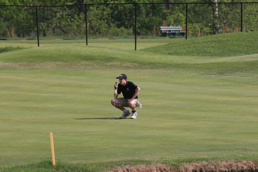 Senior Thomas Bell prepares to putt the ball into the hole in a tournament against Howell. (Photo taken on April 17 2017)