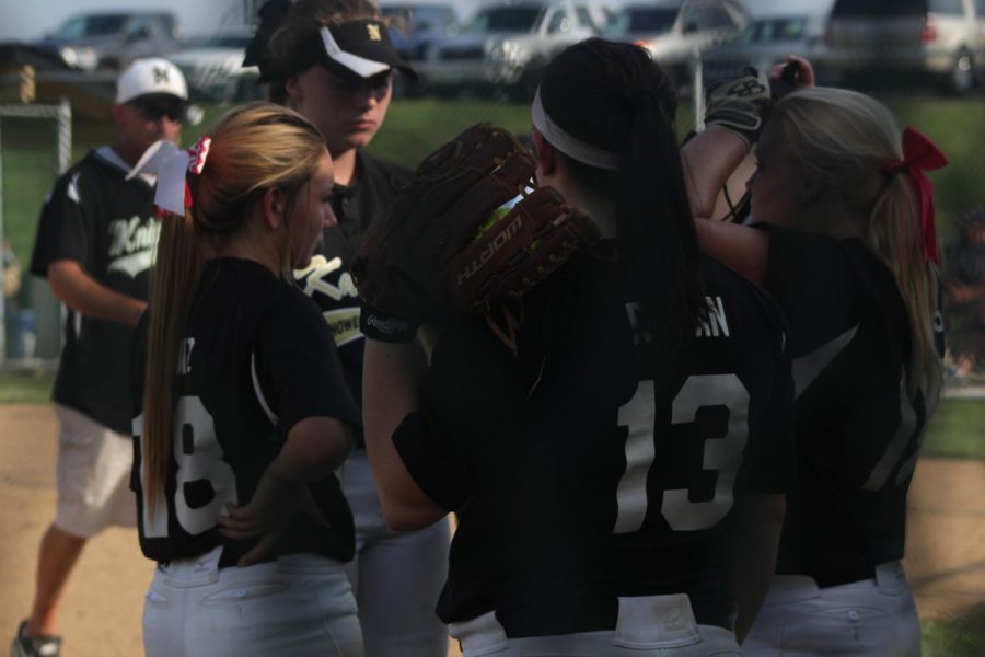 The Varsity Softball team gather together to talk strategy before heading onto the field.