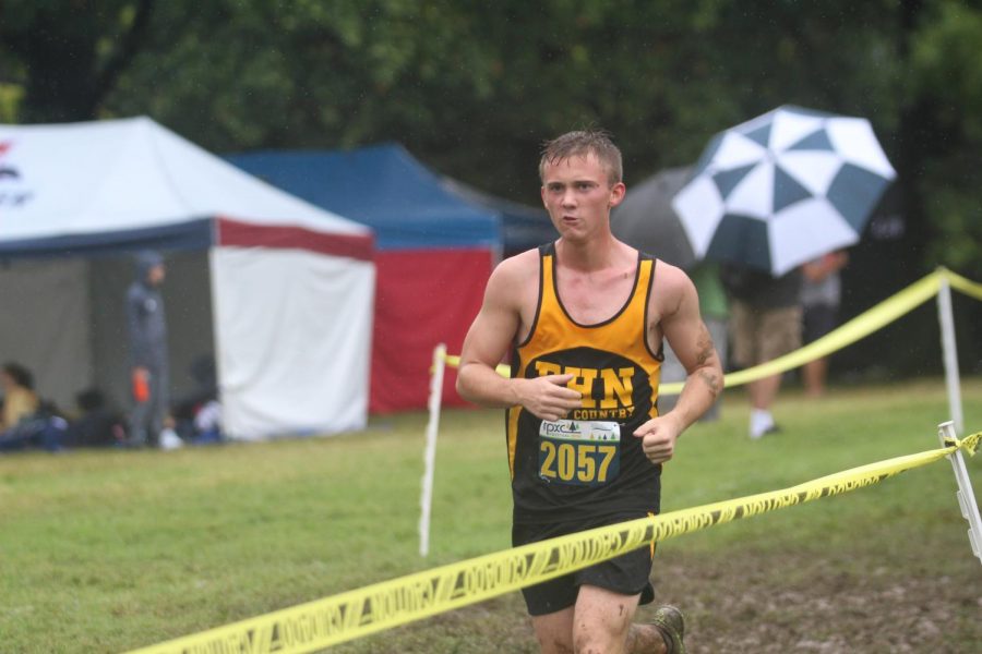 Senior Ben Ludwig runs through the mud at the Forest Park meet.