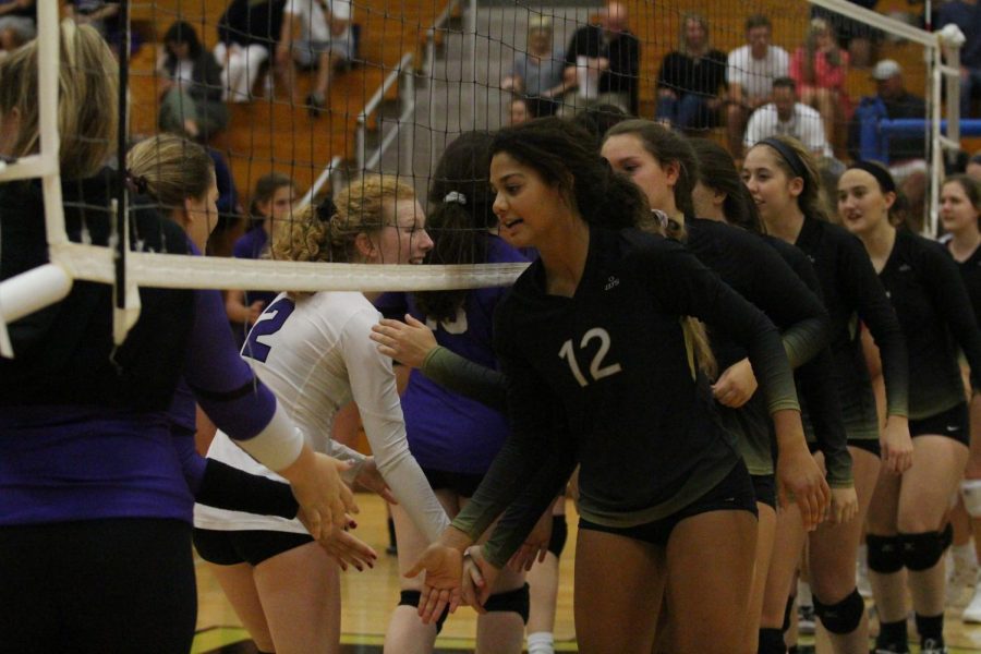 Senior Payton Stephenson high fives the opposing team before a match against Fort Zumwalt West. Stephenson is one of the two members that were voted to be team captains of the team.