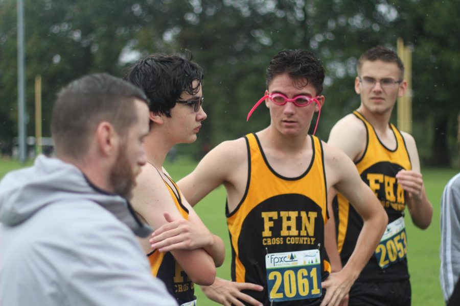 The boys cross country team listen to coach Fowler before running at Forest Park