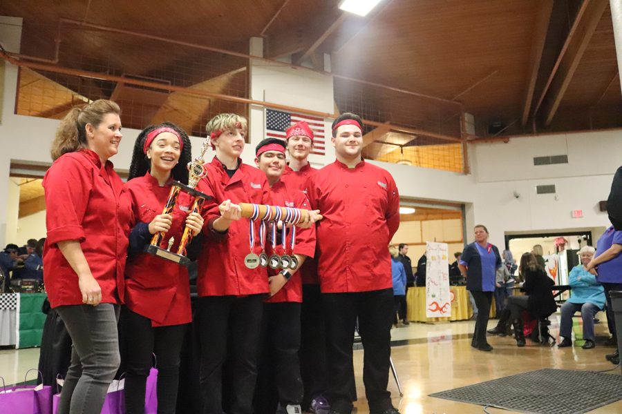 Senior Brendan Medlin holds the victory rolling pin with his Iron Chef team after their first place win. 