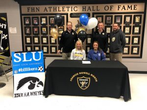 Seniors Sam Cary and Abbie Miller sit at the signing table after officially committing to their respective schools.