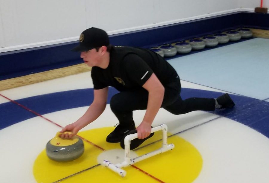 Senior Colin St. Aubin prepares to release the curling stone during a practice meet.