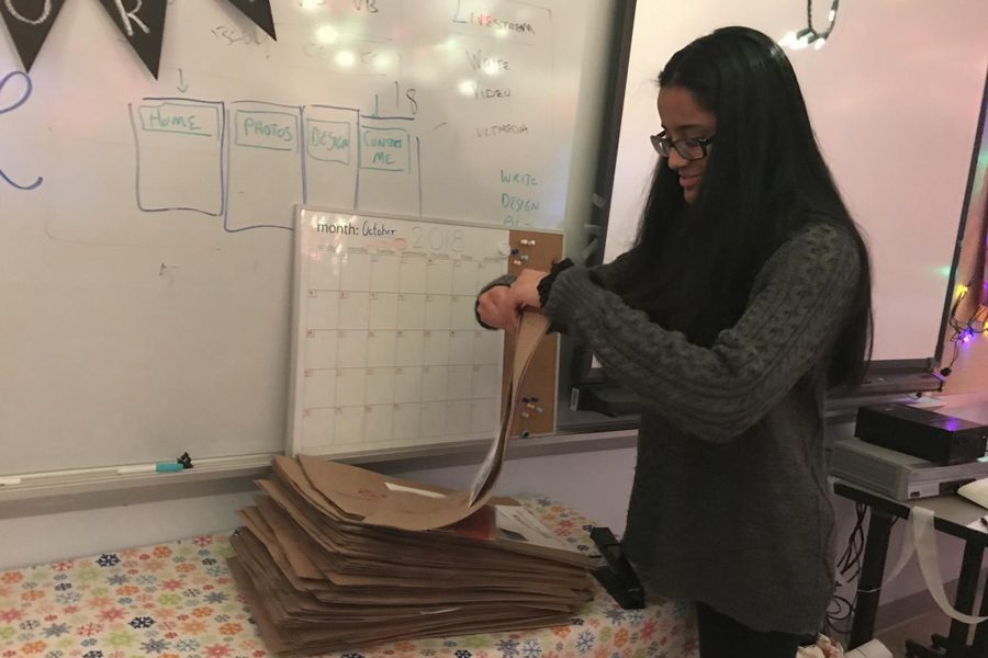 Senior Heeral Patel prepares brown paper bags to be circulated for the Dec. 10-14 Hygiene Drive.