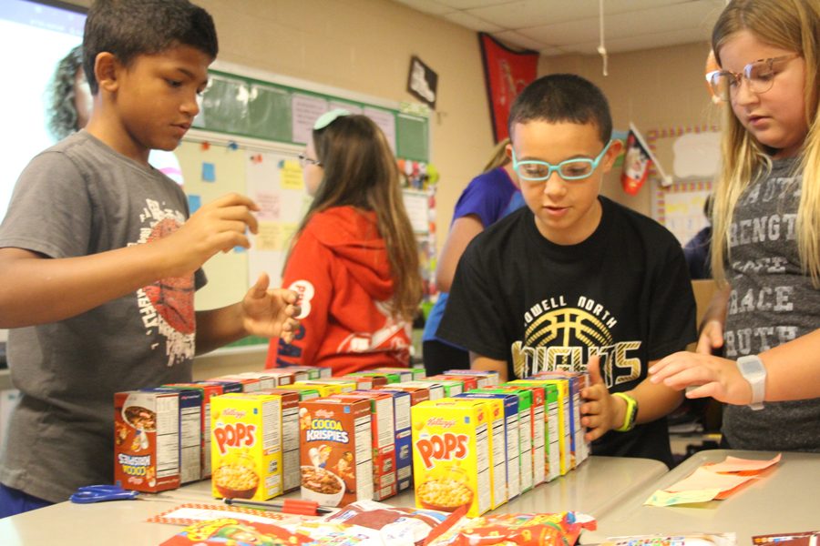 Students in Heather Bitter's fifth grade class count the number of boxes of cereal available for that week.  Every Thursday they put together bags for students in need of food on the weekend.